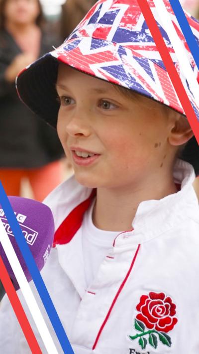 A boy wearing a union flag hat speaking into a BBC Newsround microphone on the Mall