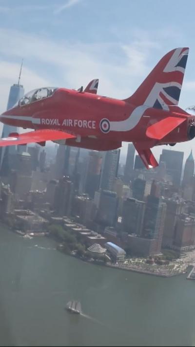 A red plane with royal air force in white writing on the side flies over Manhatten