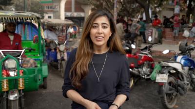 BBC correspondent Azadeh Moshiri standing in front of motor bikes on a street in Dhaka
