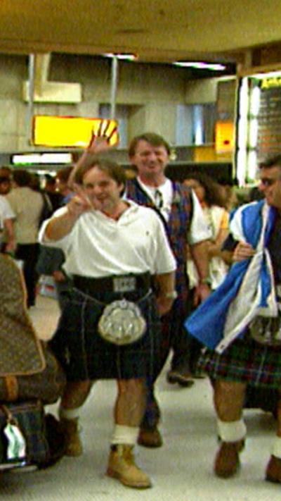 Men in kilts in airport.