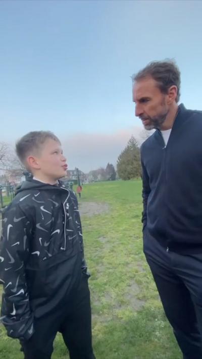 Jacob, 12, looks up toward Gareth Southgate while standing in a park