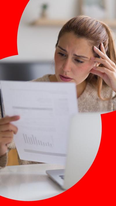 Woman sat at table looking at paper bill