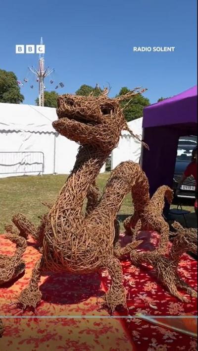 A dragon made of wicker under a bright blue sky