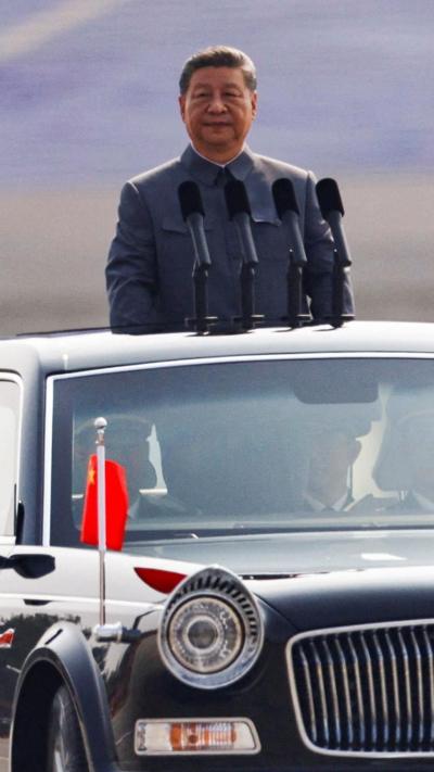 Xi stands on the back of a car
