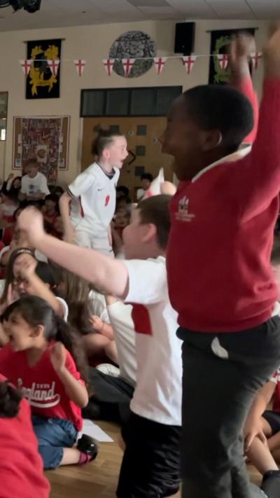 School children celebrate an England goal.