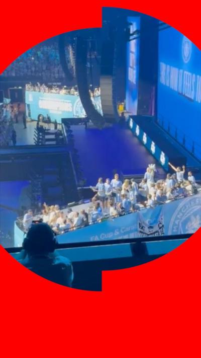The city open-top bus is in the Co-op Live arena , it is in the blue and white City branding and has players stood on top waving to the crowd.
