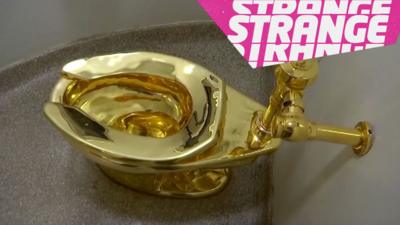 A golden toilet and the Strange logo