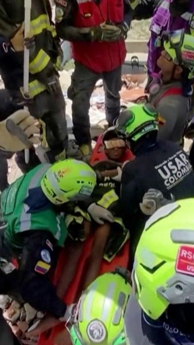 A boy on a stretcher with rescue workers around him