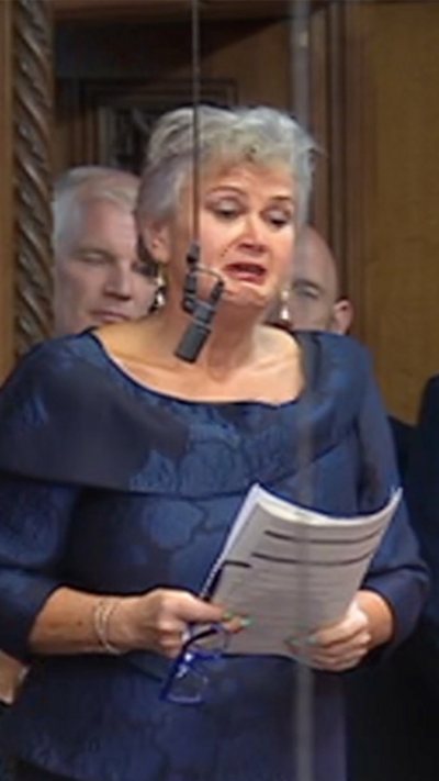 A tearful Carolyn Harris MP stood up in the House of Commons. She is wearing a blue dress and there is a hanging microphone in front of her face