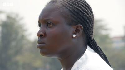 A headshot of Jackline Juma starting intently as she watches training