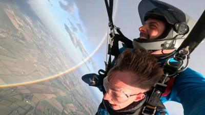 skydivers and circular rainbow
