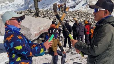 Fearghas agus Sherpa aig bonn Everest a' cluich iomain le chèile.