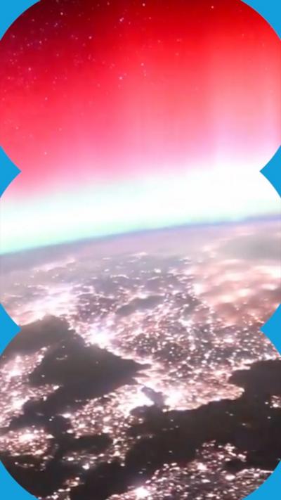 A view of lots of lights on Earth and a glowing pink sky above from the ISS