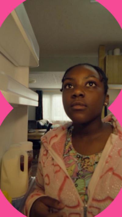 A girl looks into a fridge and sees a note with the words 'Your shelf' written on it