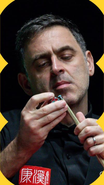 Close-up of Ronnie O'Sullivan chalking his pool cue in front of his face.