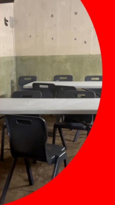 Grey and black tables and chairs set up in an underground bunker
