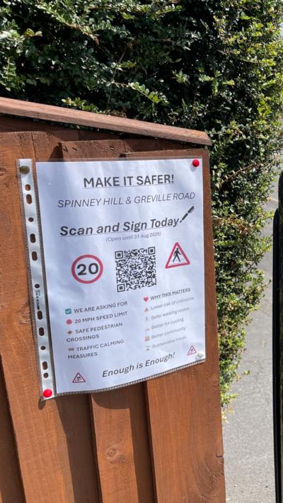 A sign saying Make it safer attached to a fence post