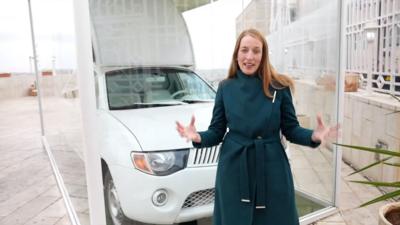The BBC's Yolande Knell stands in front of the Popemobile in Bethlehem