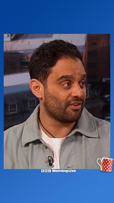 Ash Bhardwaj from shoulders upwards wearing a light blue shirt opened up with a white T-shirt underneath.