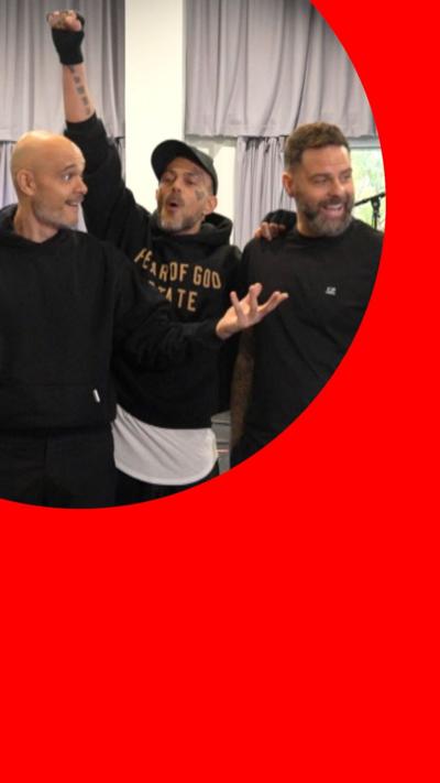 Three mean wear black hoodies with one holding up his hand