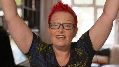 Dr Sue Black holds her hands in the air