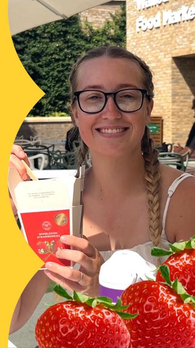 A woman with glasses and plaited pigtails with a box of strawberries