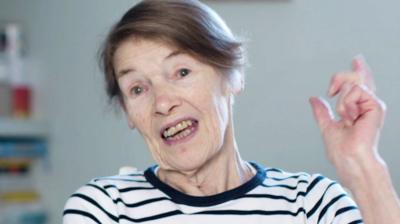 Glenda Jackson talks and holds her hand in the air