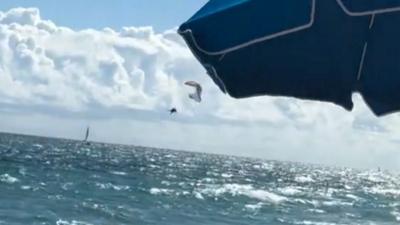 paraglider falling into the ocean