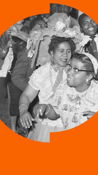 A black and white image of a crowd of people dancing together and smiling