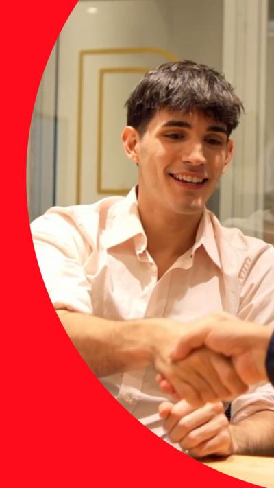 Smiling young man shaking hands across a table in an interview