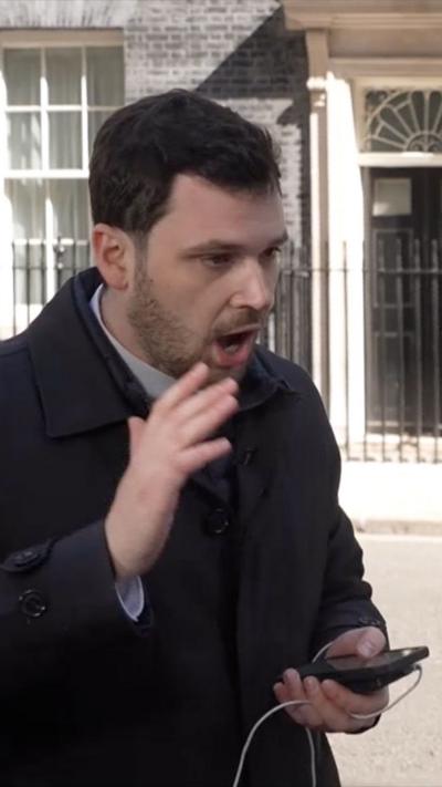 Zeffman holds his phone and speaks while motioning with his hand