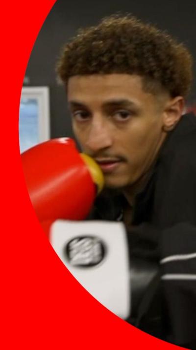 Said Abdullah in a black jacket and red boxing gloves in a ring preparing to throw a punch