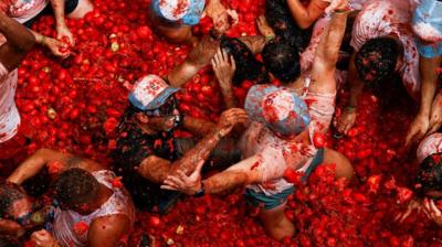  Revellers play in tomato pulp during the annual 'La Tomatina' food fight festival in Bunol