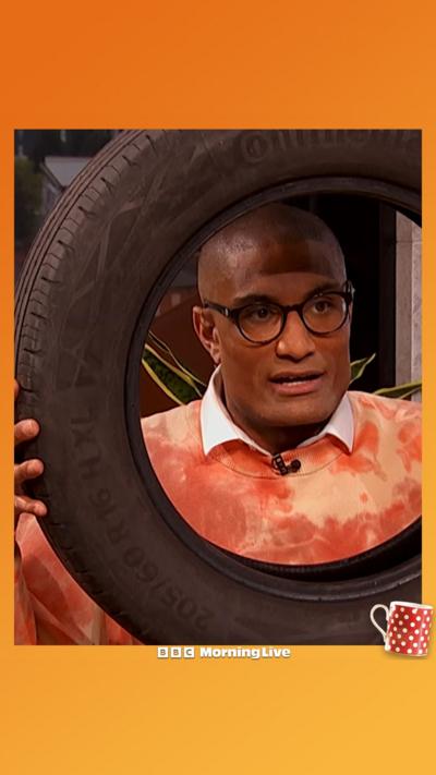 Richie Anderson poking his head out of a tyre