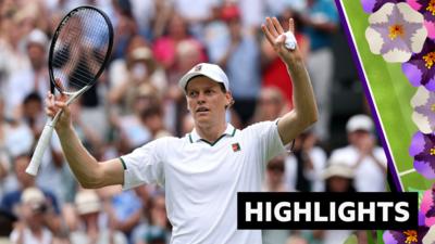 Jannik Sinner holds his arms up in the air