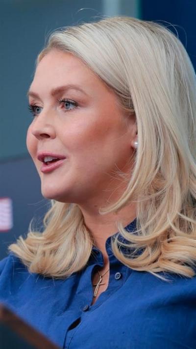 Karoline Leavitt is seen in side profile spekaing to reporters. 