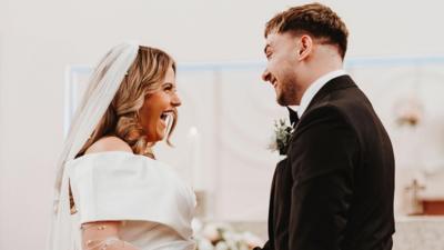 A bride and groom look at each other 
