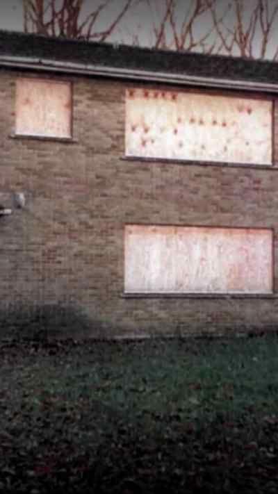 Outside of a boarded up building.