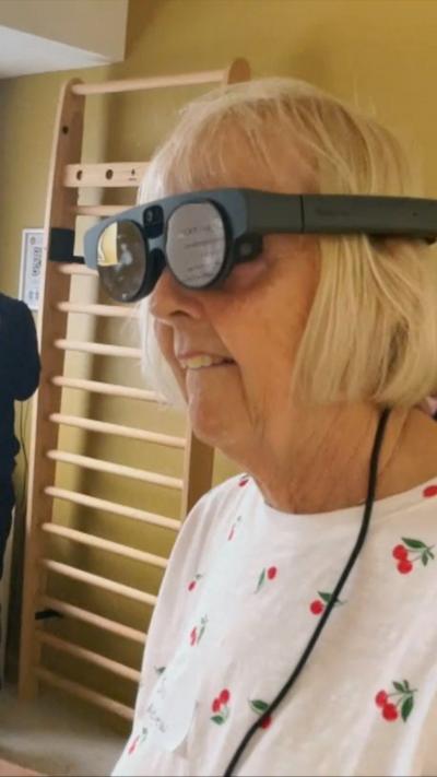 Elderly blonde woman wearing VR glasses 