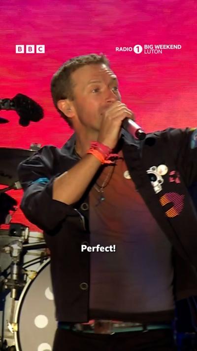 Coldplay at Radio 1 Big Weekend festival. The stage is lit up with colour.