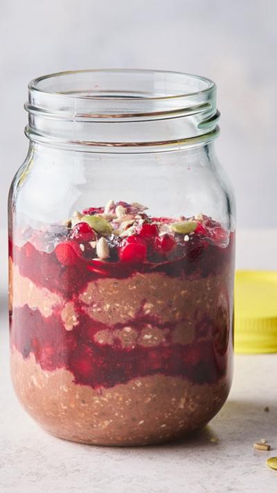 Chocolate overnight oats with summer berry compôte in a glass jar