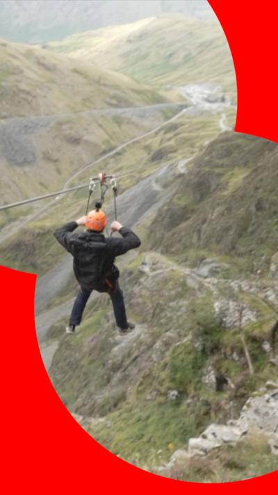 Person on zip wire ride with view of Lake District scenery