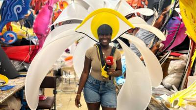 Aminata Kamara smiles at the camera whilst wearing a flowery carnival costume