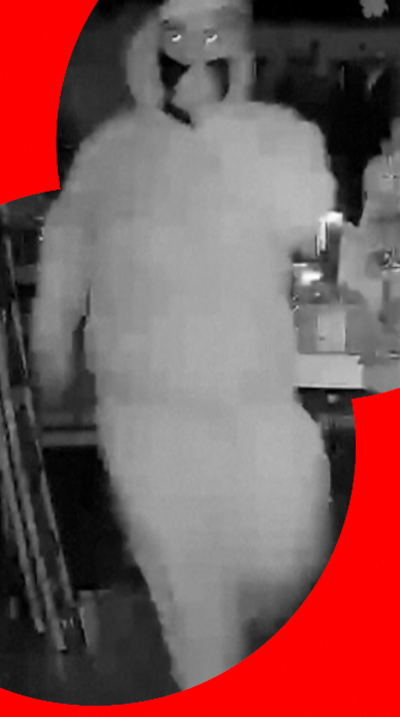 Masked man seen in black and white CCTV footage
