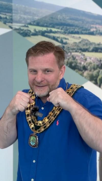 A man in a blue shirt with his fists raised to punch.