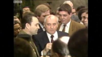 Mikhail Gorbachev stands in the middle of a crowd of people