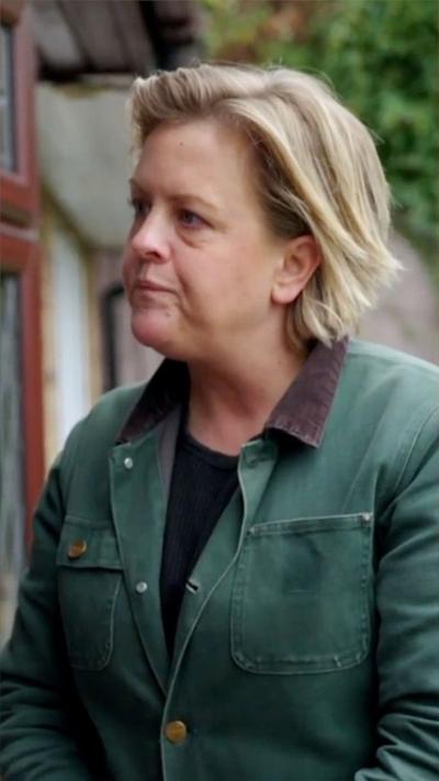 A woman with collar-length blonde hair stands outside a house with a concerned look on her face
© BBC