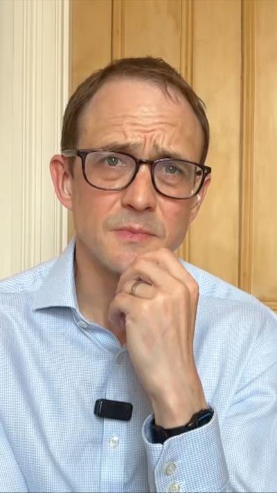 Chris Mason in glasses and a blue shirt looks at the camera