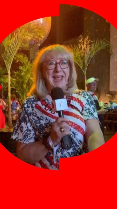 Donna Kelce holding a mic and wearing a red blue and white t-shirt