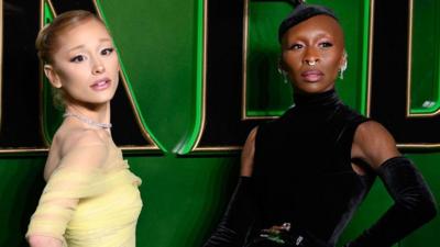 Ariana Grande wearing a lemon dress and Cynthia Erivo wearing a black dress attend the Wicked: Part One UK Premiere at The Royal Festival Hall on 18 November 2024 in London, England